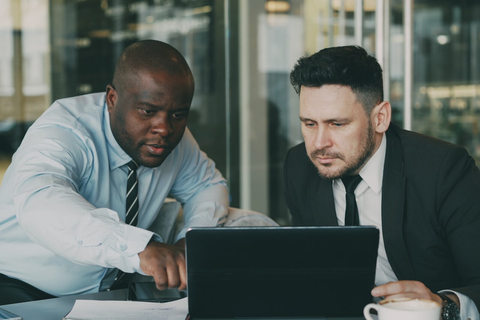 A technical advisor walking through findings on a laptop with a client