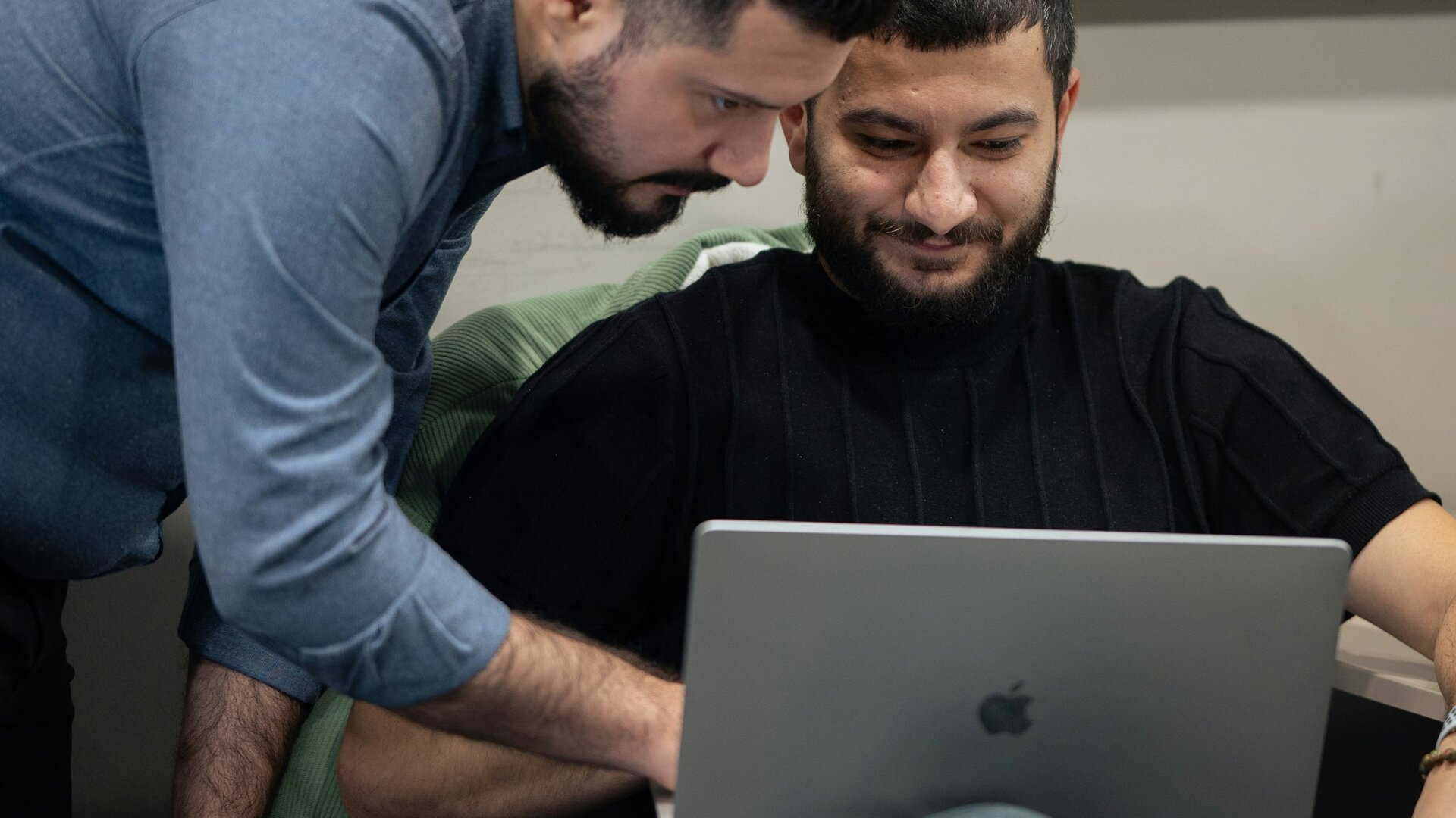 Two engineers reviewing source code together on a laptop